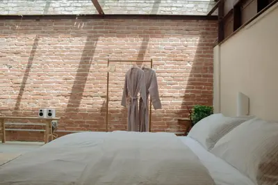 a bed in a room with a brick wall at Mane & Saddle Loft in Los Angeles