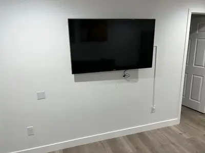 a flat screen tv hanging on a white wall at Brand new private one bed one bath home with private parking for 2 in Van Nuys Airport
