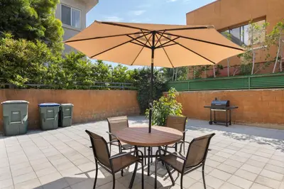 a wooden table with chairs and an umbrella at Adorable Pasadena Bungalow in Pasadena