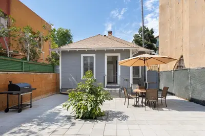 a house with a patio with a table and an umbrella at Adorable Pasadena Bungalow in Pasadena