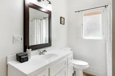 a white bathroom with a sink and a mirror at Adorable Pasadena Bungalow in Pasadena