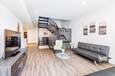 a living room with a couch and a staircase at Sunset Boulevard Apartments in Los Angeles
