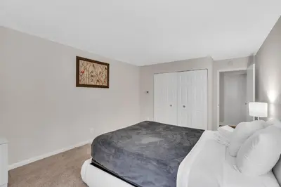 a white bedroom with a large bed and a cabinet at Sunset Boulevard Apartments in Los Angeles