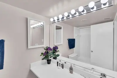 a bathroom with a sink and a large mirror at Sunset Boulevard Apartments in Los Angeles