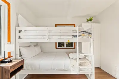 a white bunk bed in a white room with a desk at Cute Romantic Cabin With Hot Tub 5 Min from Lake in Crestline
