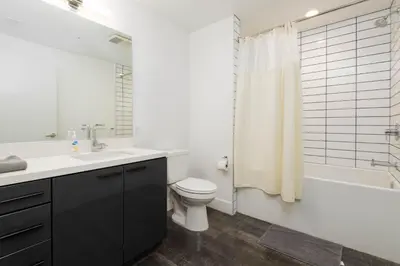 a bathroom with a sink and a toilet and a shower at Stunning 3BR High Rise Pool, Spa & Rooftop Views in Los Angeles