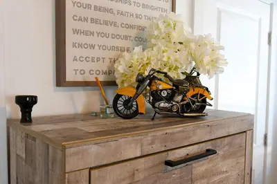 a motorcycle sitting on top of a wooden dresser with flowers at Urban Oasis in Los Angeles