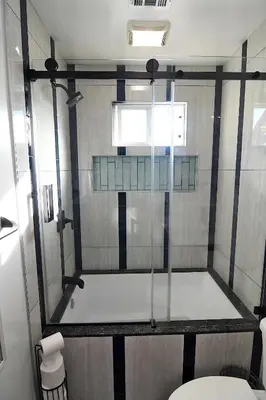 a bathroom with a glass shower with a toilet at Urban Oasis in Los Angeles