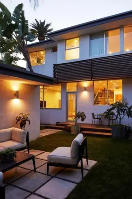 a house with two chairs and a table in a yard at Architectural Walk Street Home Venice Elegance in Los Angeles