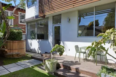 a house with a wooden deck with a table and chairs at Architectural Walk Street Home Venice Elegance in Los Angeles