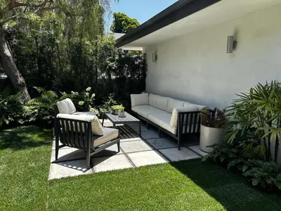 a patio with a couch and two chairs and a table at Architectural Walk Street Home Venice Elegance in Los Angeles