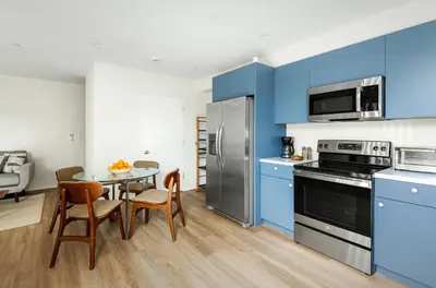 a kitchen with blue cabinets and a table with chairs at Modern Mar Vista Hideaway New TwoStory ADU in Los Angeles