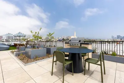 a patio with a table and chairs on a roof at Westwood Penthouse 3 Bedroom 2 Bath w Gym, Balcony, Parking in Los Angeles