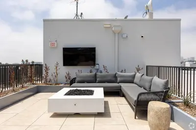 a patio with a couch and a tv on a balcony at Westwood Penthouse 3 Bedroom 2 Bath w Gym, Balcony, Parking in Los Angeles
