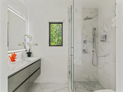 a white bathroom with a shower and a sink at Casa Leona in Los Angeles