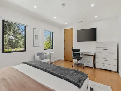 a bedroom with a bed and a desk and a tv at Casa Leona in Los Angeles