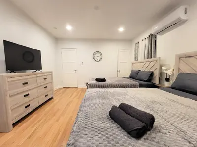 a bedroom with two beds and a flat screen tv at Private and large 2 bedroom house with Pool table, backyard and office near attractions in Los Angeles