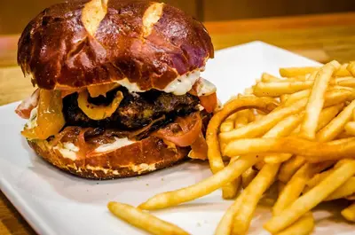 a hamburger and french fries on a white plate at Private and large 2 bedroom house with Pool table, backyard and office near attractions in Los Angeles