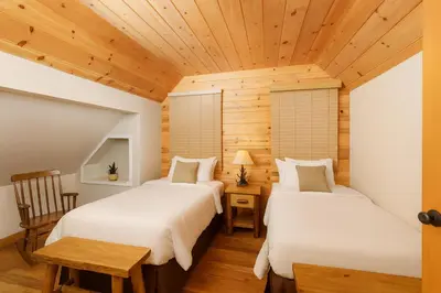 two beds in a room with wooden ceilings at Cozy Cabin with Large Backyard Near Lake, Village and Snow Summit in Big Bear Lake