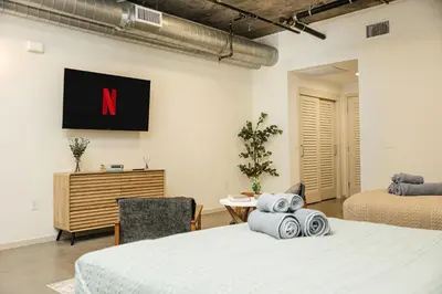 a bedroom with a large bed and a tv on the wall at Spectacular LOFT in Heart of LA with GYM, Pool, parking in Los Angeles
