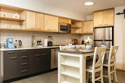 a kitchen with wooden cabinets and a table and chairs at Spectacular LOFT in Heart of LA with GYM, Pool, parking in Los Angeles