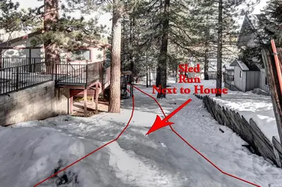a house in the snow with a sign that reads slept him next to house at Gold Rush in Big Bear Lake