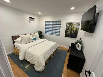 a bedroom with a large bed and a window at Coastal Calm Casita in Long Beach