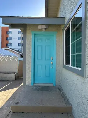 a blue door on the side of a house at Coastal Calm Casita in Long Beach