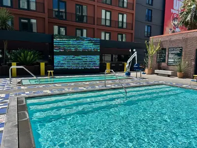 a swimming pool with a large screen in a building at Chic Hollywood Dream Large Studio in Los Angeles