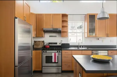 a kitchen with wooden cabinets and stainless steel appliances at Amenity-Rich Abbot Kinney Venice Oasis! in Los Angeles
