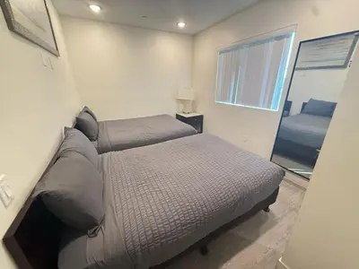 a small bedroom with a bed and a mirror at Urban Chic residence in Central LA in Los Angeles