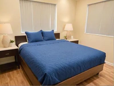 a bedroom with a blue bed with two night stands at Urban Chic residence in Central LA in Los Angeles