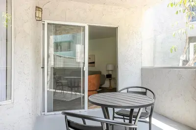 a table and chairs on a balcony with a table at Blueground Pasadena pool nr Pasadena Park LAX-1391 in Los Angeles