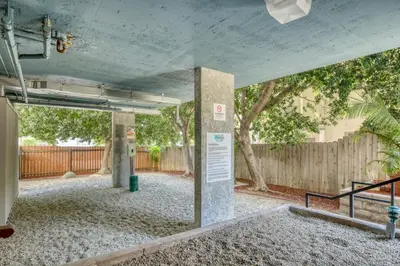 an empty parking lot with a fence and trees at Blueground Pasadena pool nr Pasadena Park LAX-1391 in Los Angeles