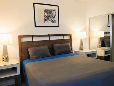 a bedroom with a bed with two lamps and a mirror at Venice Beach Getaway Steps from the Ocean Marina and Boardwalk in Los Angeles
