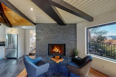 a living room with two chairs and a fireplace at Koda House in Lake Arrowhead