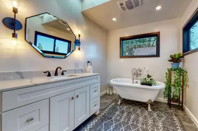 a bathroom with a tub and a sink and a mirror at Koda House in Lake Arrowhead