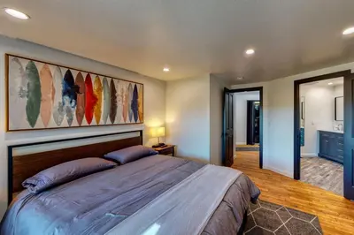 a bedroom with a large bed with a large painting on the wall at Koda House in Lake Arrowhead