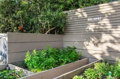 a retaining wall with a sign that says stay awhile at Amara by Stay Awhile Villas in Los Angeles