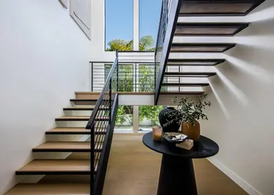 a staircase in a house with a table at Amara by Stay Awhile Villas in Los Angeles