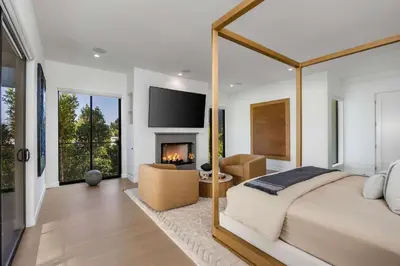 a bedroom with a large bed and a fireplace at Amara by Stay Awhile Villas in Los Angeles