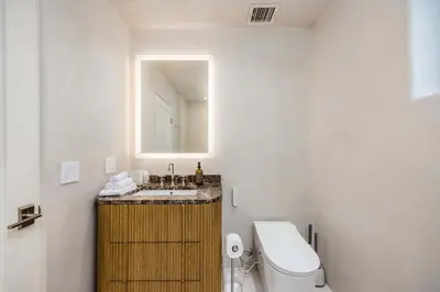 a bathroom with a sink and a toilet and a mirror at Amara by Stay Awhile Villas in Los Angeles