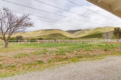 a field with a fence and mountains in the background at Patio, Fire Pit and Hillside Views Agua Dulce Home in Leona Valley