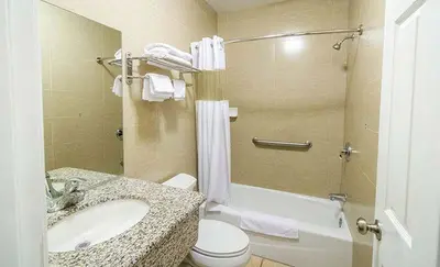 a bathroom with a sink and a toilet and a tub at Carlton Motor Lodge in Los Angeles