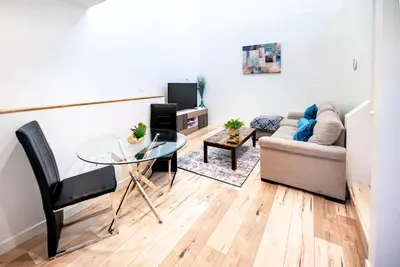 a living room with a glass table and a couch at Modern 2 Bedroom 3 Level Loft by Hollywood Close to Downtown LA Free Gated Parking Full Kitchen in Los Angeles
