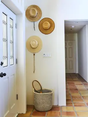 a hallway with straw hats hanging on the wall at Oja Mountain Ridge in Ojai