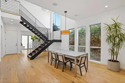 a dining room with a table and a staircase at Vast Mar Vista Residence in Los Angeles