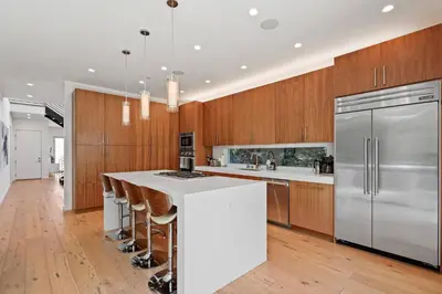 a kitchen with a white island and wooden cabinets at Vast Mar Vista Residence in Los Angeles