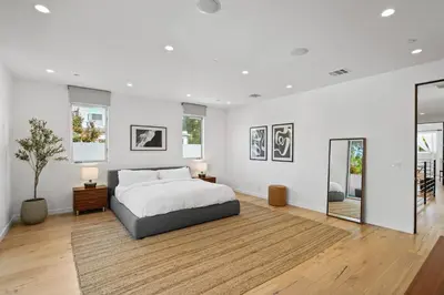 a white bedroom with a bed and two mirrors at Vast Mar Vista Residence in Los Angeles
