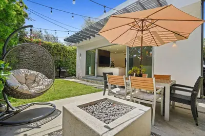 a patio with a table with an umbrella and chairs at Vast Mar Vista Residence in Los Angeles